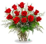A bouquet of vibrant red roses in a clear glass vase.