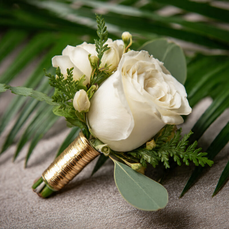 Close-up of white flowers with green leaves on wooden surface.