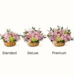Three versions of the "Beautiful Spirit" flower basket arrangement—Standard, Deluxe, and Premium—displayed in wooden baskets with pink lilies, roses, and green chrysanthemums.