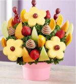 Make Mother’s Day extra sweet with this deluxe edible arrangement. Bright pineapple flowers with grape centers are surrounded by juicy strawberries, ripe cantaloupe, honeydew, and orange slices, plus chocolate-dipped strawberries swirled with white chocolate. All arranged in a cheerful pink keepsake container with a festive “Happy Mother’s Day” balloon. A delicious gift that’s as beautiful as it is thoughtful.