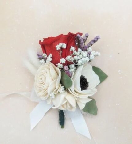 Red preserved rose boutonniere with ivory sola wood flowers, baby's breath, and lavender accents, tied with a white satin ribbon