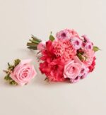 Pink and fuchsia prom flower set featuring a hand-tied bouquet with roses, carnations, alstroemeria, and daisies beside a matching single rose boutonniere with greenery, all on a light beige background.